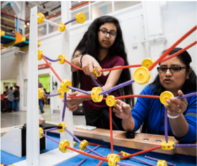 Two teenage girls playing with Tinker Toys