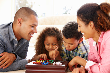 Two parents and two children playing a board game