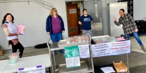 four school staff distributing meals standing 6 feet apart