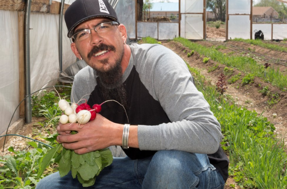 A person in a garden holding fresh radishes