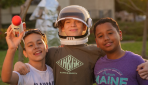 3 middle school friends with an astronaut helmet on one of them